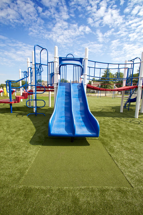 Blue slide on artificial grass playground