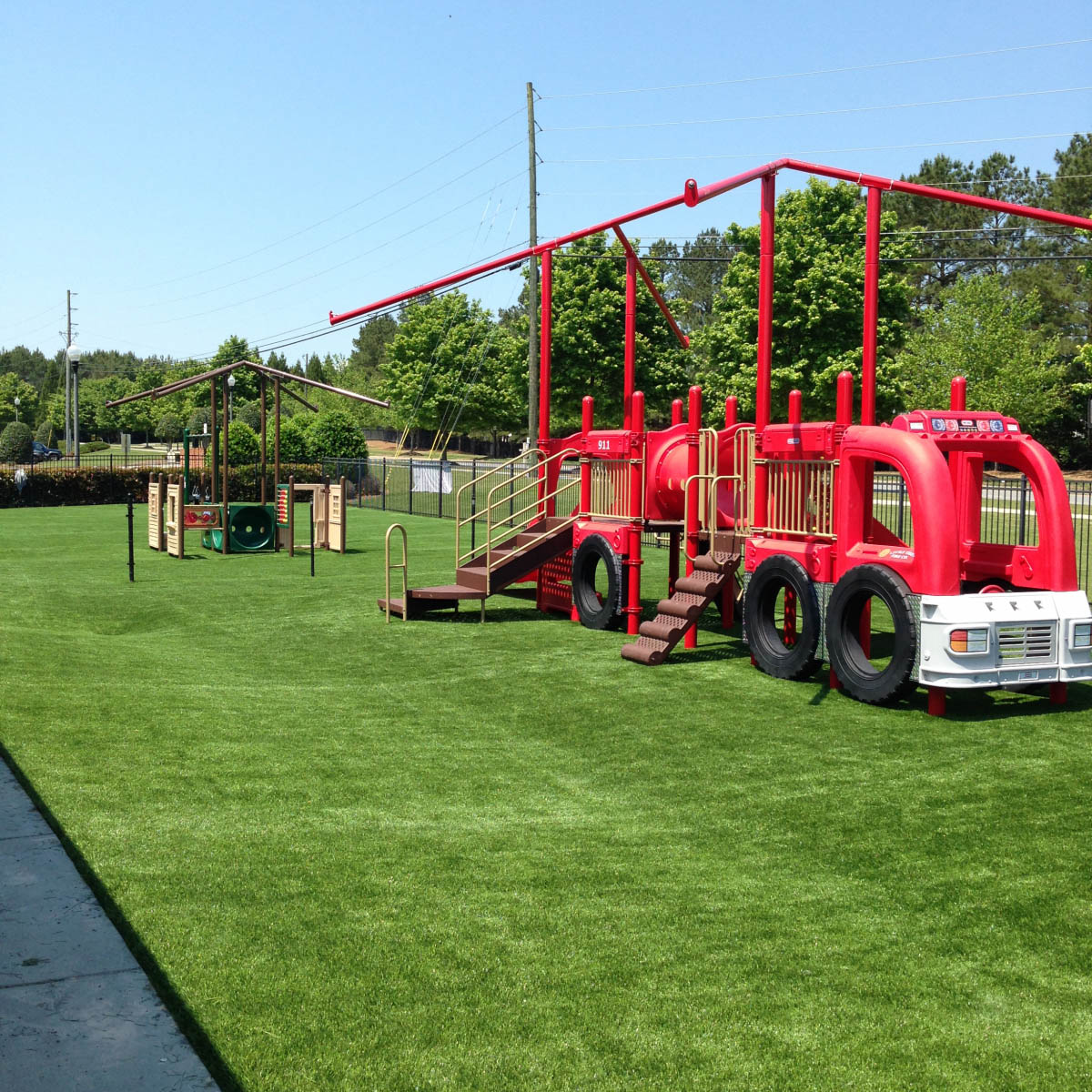 Artificial grass playground with firetruck jungle gym